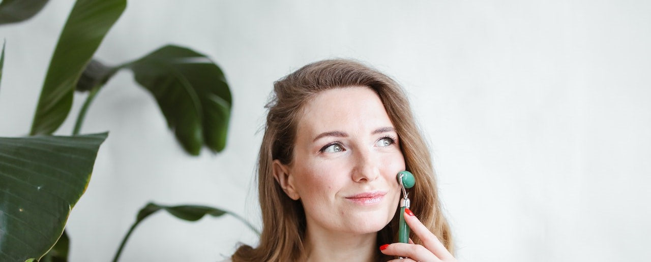 Femme utilise rouleaux de massage sur visage