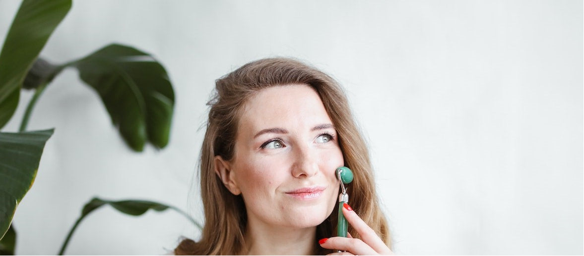 rouleau de massage tenir par femme sur visage