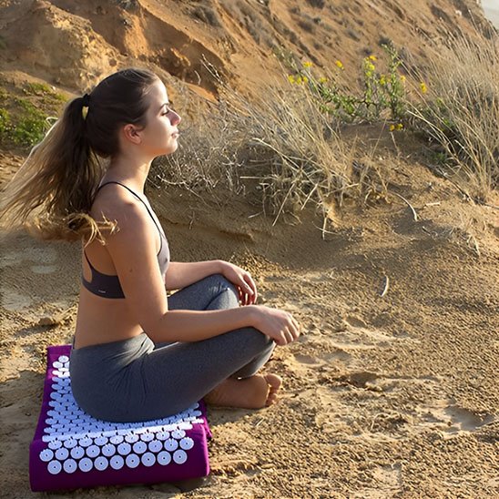personne-croise-jambe-sur-tapis-d-acupression-violet